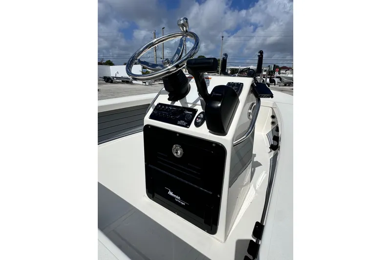 Slide: The Image of 2022 Maverick 18 HPX-V boat console with steering wheel and controls under a cloudy sky. - 19