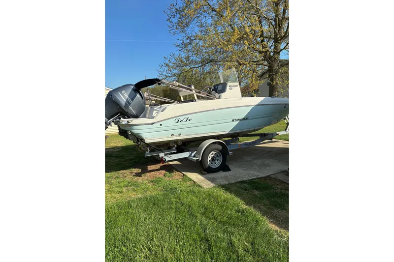 The Image of 2017 Stingray 206 CC boat on trailer, parked on grass under clear blue sky. - 1