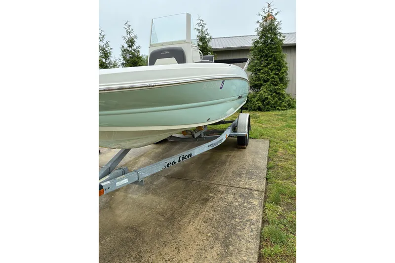Slide: The Image of 2017 Stingray 206 CC boat on trailer, parked outdoors near greenery. - 3