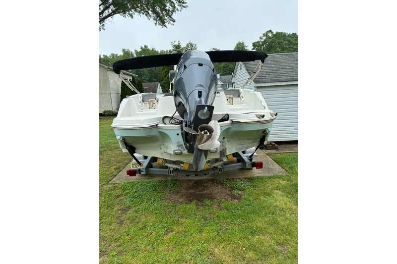 Slide: The Image of 2017 Stingray 206 CC boat on trailer, parked in a grassy yard. - 4