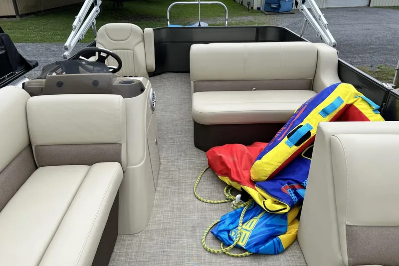 Slide: The Image of 2016 Crest I 220 pontoon boat interior with beige seating and colorful inflatable tubes. - 10
