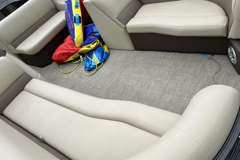 Slide: The Image of Interior of 2016 Crest I 220 boat with beige seating and colorful life jackets. - 11