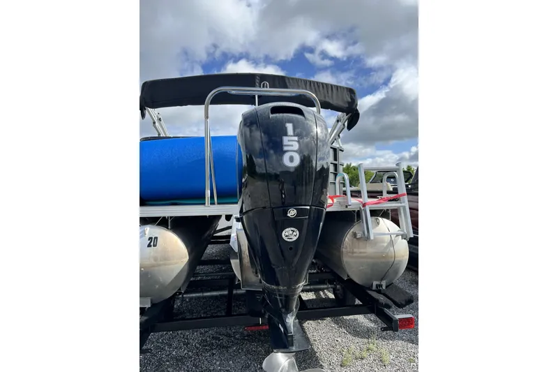 Slide: The Image of 2016 Crest I 220 pontoon boat with 150 HP outboard motor, parked on gravel. - 3