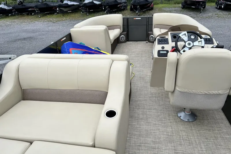 Slide: The Image of 2016 Crest I 220 pontoon boat interior with beige seating and steering console. - 7