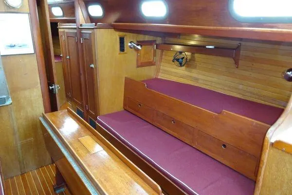 Slide: The Image of Interior of a 1964 Hinkley Bermuda 40 sailboat with wooden furnishings and maroon seating. - 18