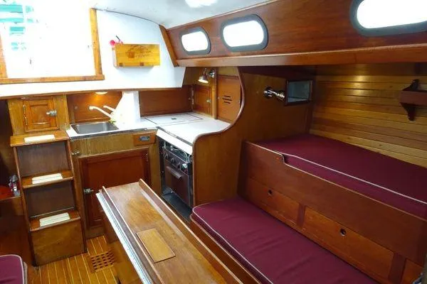 Slide: The Image of Interior of a 1964 Hinkley Bermuda 40 sailboat with wooden furnishings and compact kitchen. - 19