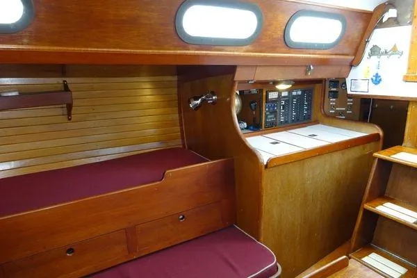 Slide: The Image of Interior of a 1964 Hinkley Bermuda 40 sailboat with wooden cabinetry and maroon cushions. - 21