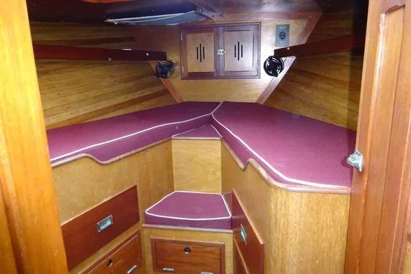 Slide: The Image of Interior cabin of a 1964 Hinkley Bermuda 40 sailboat with wooden finish and red cushions. - 24