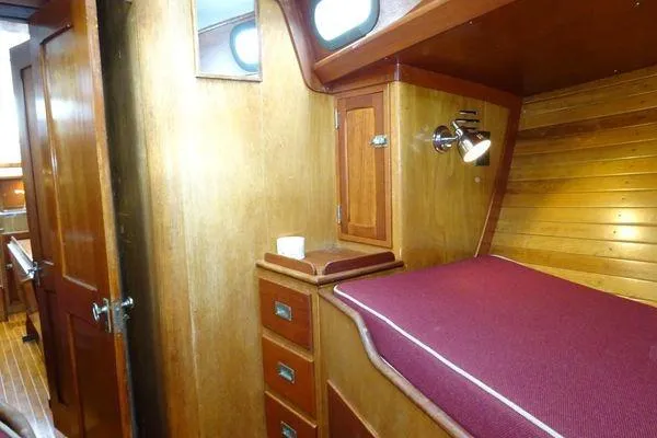 Slide: The Image of Interior of 1964 Hinkley Bermuda 40 sailboat with wooden cabinetry and cozy sleeping area. - 26