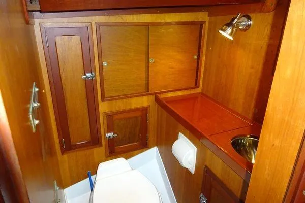 Slide: The Image of Wood-paneled bathroom interior of 1964 Hinkley Bermuda 40 yacht with sink and storage cabinets. - 28