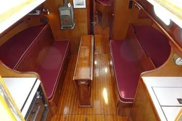 Slide: The Image of Interior of a 1964 Hinkley Bermuda 40 sailboat with wooden finishes and red seating. - 31