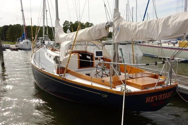 Slide: The Image of 1964 Hinkley Bermuda 40 sailboat docked at marina, featuring classic design and wooden deck. - 4