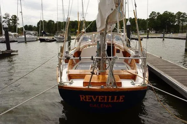 Slide: The Image of 1964 Hinkley Bermuda 40 sailboat docked at marina, named "Reveille." - 5