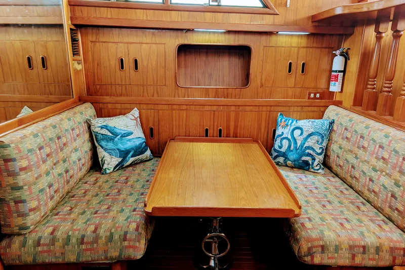 Slide: The Image of 1989 President 37 Double Cabin interior with wooden table, patterned seating, and marine-themed pillows. - 11