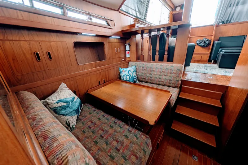 Slide: The Image of 1989 President 37 Double Cabin interior with wooden decor, cozy seating, and a dining table. - 12