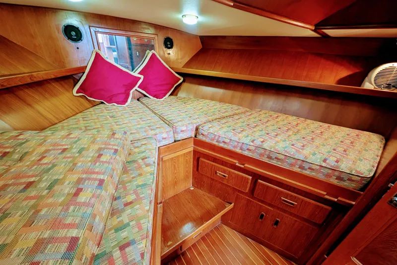 Slide: The Image of 1989 President 37 Double Cabin interior with patterned bedding and red pillows. - 14