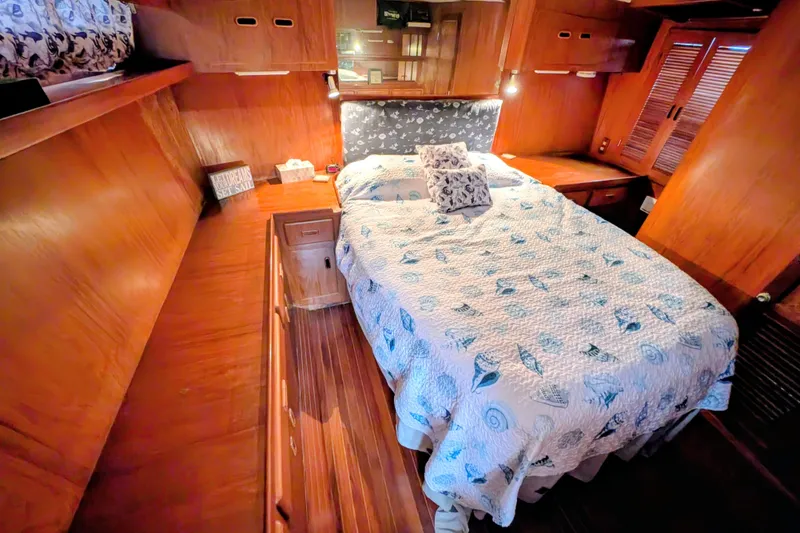 Slide: The Image of Cozy cabin interior of 1989 President 37 Double Cabin with wooden furnishings and nautical bedding. - 15