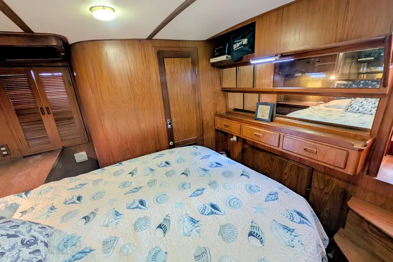 Slide: The Image of Cozy cabin interior of 1989 President 37 Double Cabin with wood paneling and nautical bedding. - 16