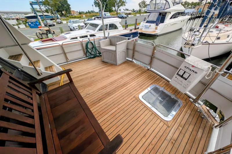 Slide: The Image of 1989 President 37 Double Cabin yacht deck with wooden flooring and marina view. - 2