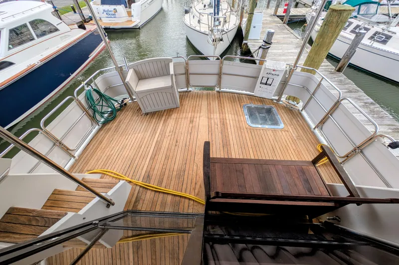 Slide: The Image of 1989 President 37 Double Cabin yacht deck with wooden flooring and dock view. - 3