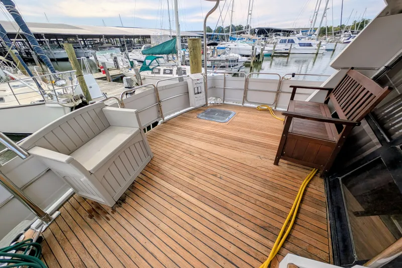 Slide: The Image of 1989 President 37 Double Cabin yacht deck with wooden flooring and seating at marina. - 4