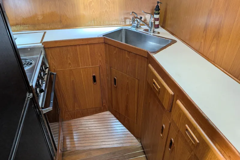 Slide: The Image of 1989 President 37 Double Cabin yacht kitchen with wood cabinetry and stainless steel sink. - 7