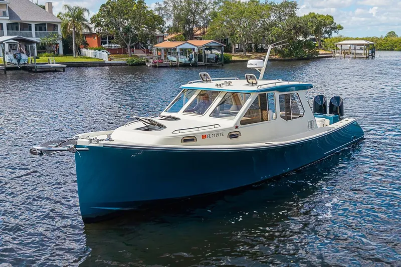 The Image of 2002 True North 38 boat on a scenic waterfront with houses and trees. - 0