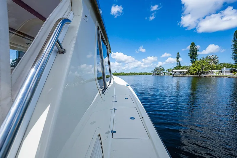 Slide: The Image of True North 38 boat cruising on a serene lake, clear blue sky, 2002 model. - 10
