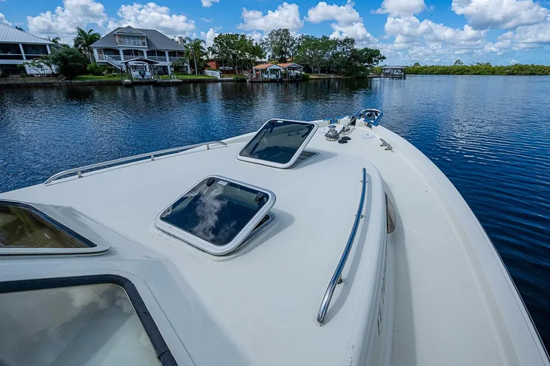 Slide: The Image of Bow view of 2002 True North 38 yacht on a serene waterfront. - 12
