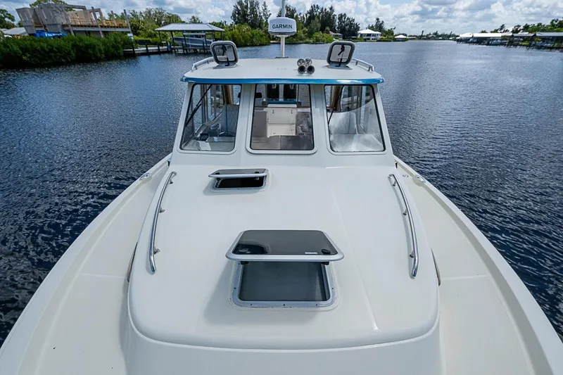 Slide: The Image of 2002 True North 38 boat on calm water, featuring a sleek deck and cabin. - 14