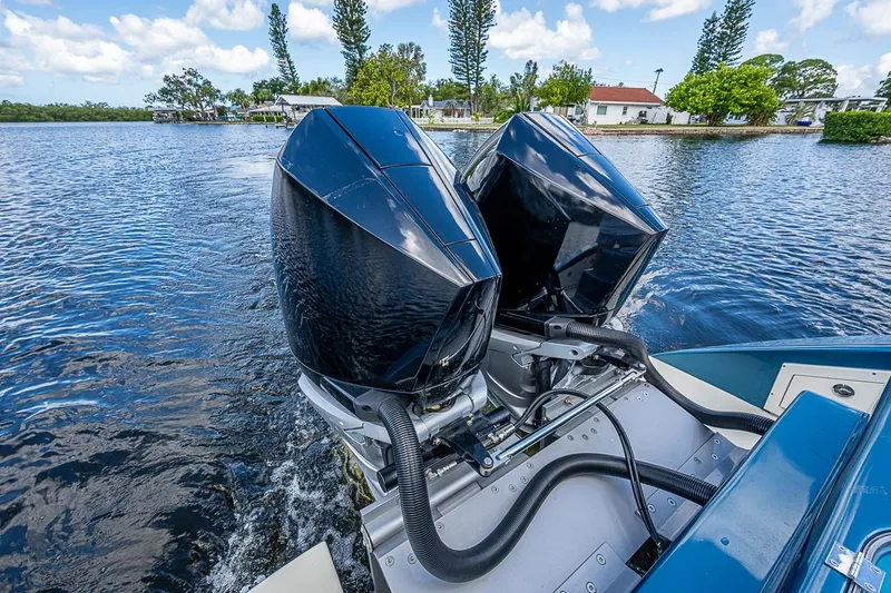Slide: The Image of Twin outboard motors on a 2002 True North 38 boat, cruising on a scenic waterway. - 18