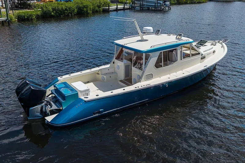 Slide: The Image of 2002 True North 38 boat on calm water, featuring a sleek blue and white design. - 3