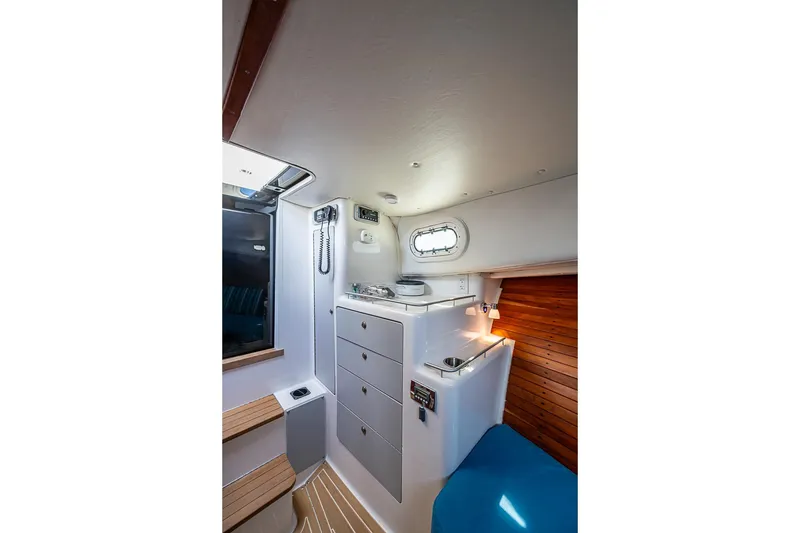 Slide: The Image of Interior of 2002 True North 38 boat, featuring compact cabin with storage and lighting. - 30