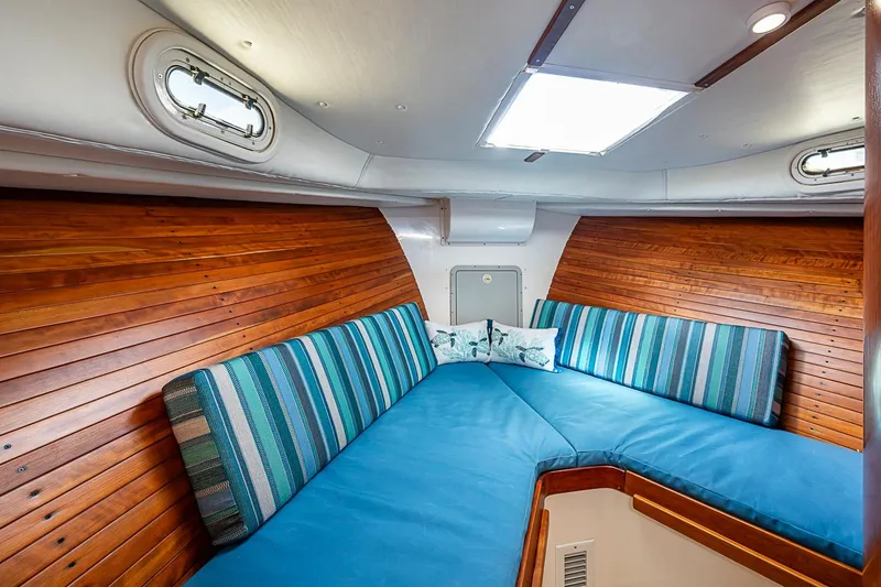 Slide: The Image of Cozy cabin interior of 2002 True North 38 boat with striped cushions and wooden paneling. - 32