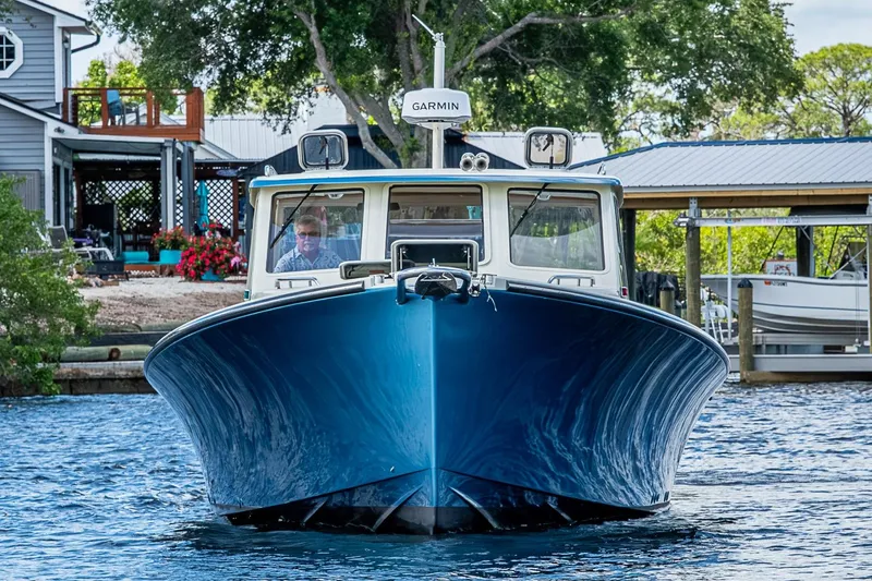 Slide: The Image of 2002 True North 38 boat on water, front view, near dock with trees and house. - 4