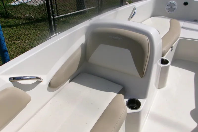 Slide: The Image of 2018 Stingray 182 SC boat interior with beige seating and cup holders. - 12
