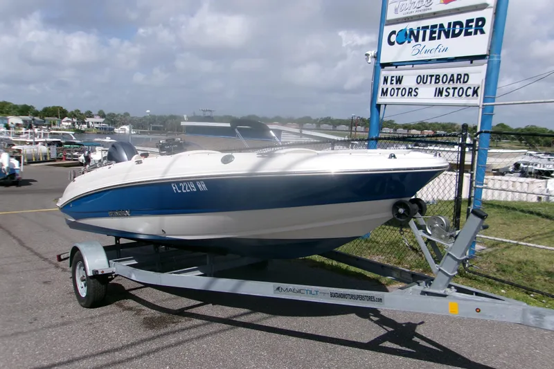 Slide: The Image of 2018 Stingray 182 SC boat on trailer at dealership, sunny day. - 2