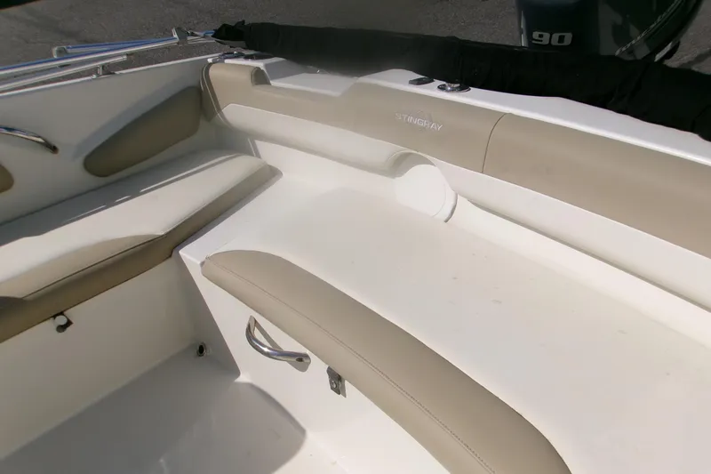 Slide: The Image of Interior seating of a 2018 Stingray 182 SC boat, featuring beige cushions and sleek design. - 5