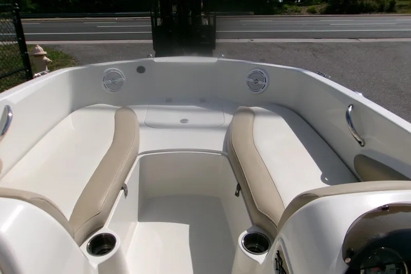 Slide: The Image of 2018 Stingray 182 SC boat interior with beige seating and cup holders. - 7