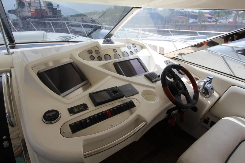 Slide: The Image of Cockpit of 2001 Sunseeker Predator 56 yacht with steering wheel and navigation controls. - 2