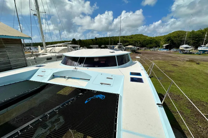 Slide: The Image of Catamaran Alibi 54, 2011 model, docked in a marina under a partly cloudy sky. - 21
