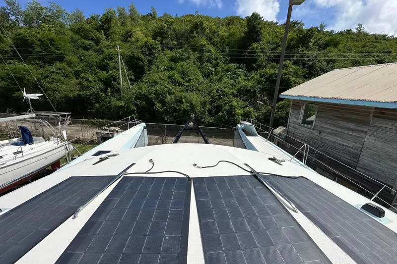 Slide: The Image of Solar panels on Alibi 54 boat deck, surrounded by lush greenery and clear sky. - 22
