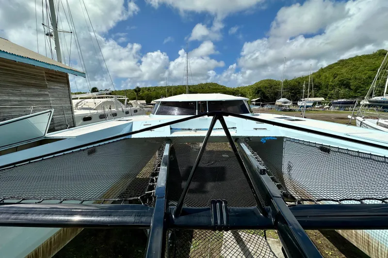 Slide: The Image of Catamaran Alibi 54, 2011 model, docked with scenic marina backdrop under blue sky. - 23