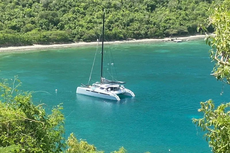 Slide: The Image of Catamaran Alibi 54 (2011) anchored in turquoise bay near lush green shoreline. - 30