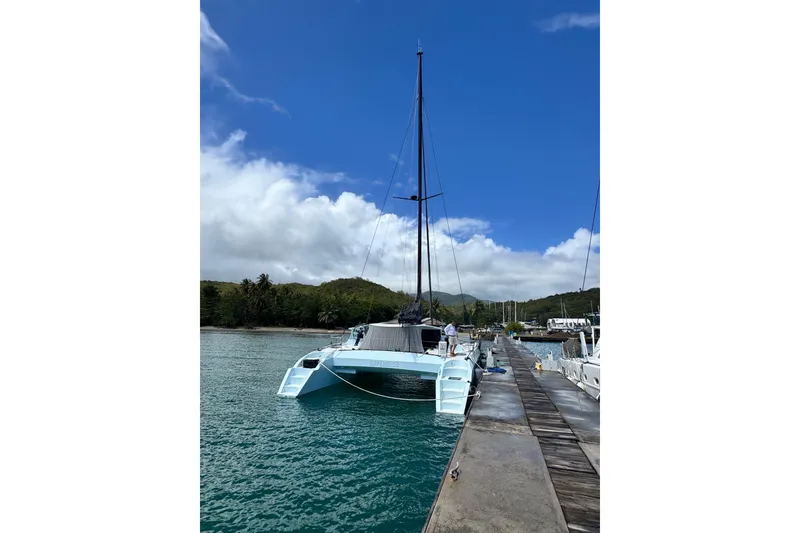 Slide: The Image of Sleek 2011 Alibi 54 catamaran docked in a tropical marina under a clear blue sky. - 5