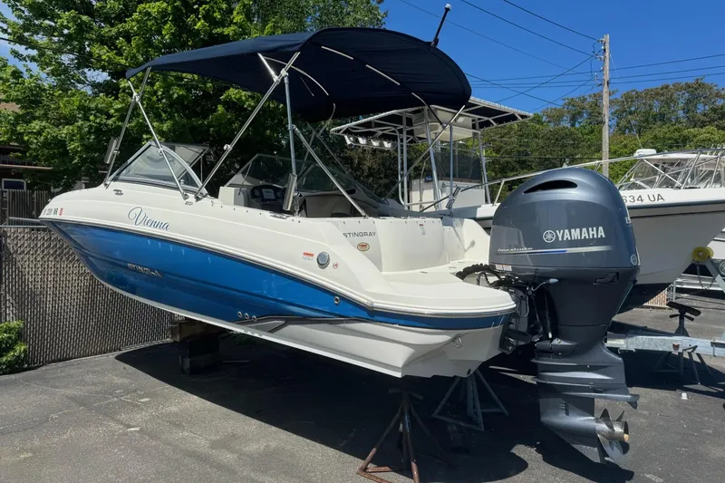 Slide: The Image of 2018 Stingray 201 DC boat with Yamaha outboard motor, parked outdoors. - 8