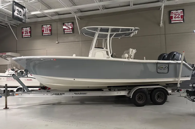 The Image of 2016 Sea Hunt Gamefish 25 boat on trailer in indoor showroom. - 0