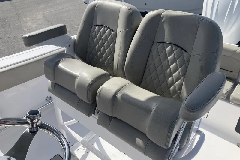 Slide: The Image of 2024 Sportsman Heritage 231 Center Console boat seats with diamond-stitched upholstery and armrests. - 12