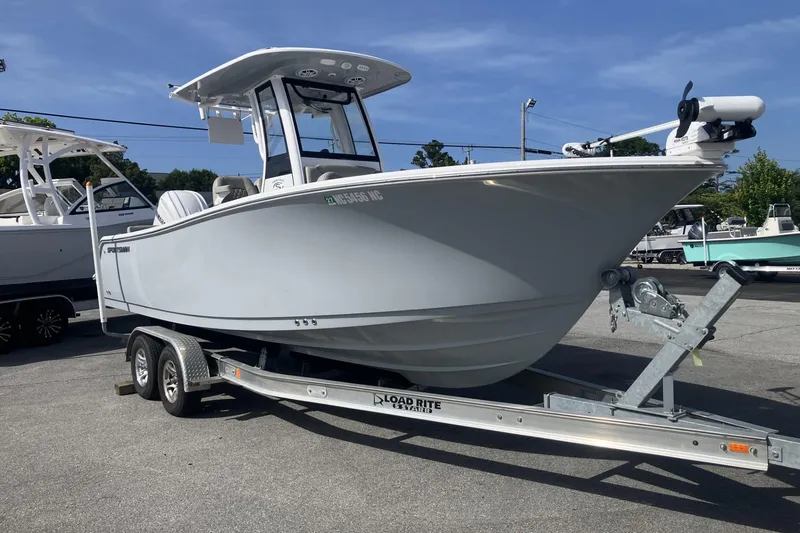 Slide: The Image of 2024 Sportsman Heritage 231 Center Console boat on trailer, parked outdoors. - 2