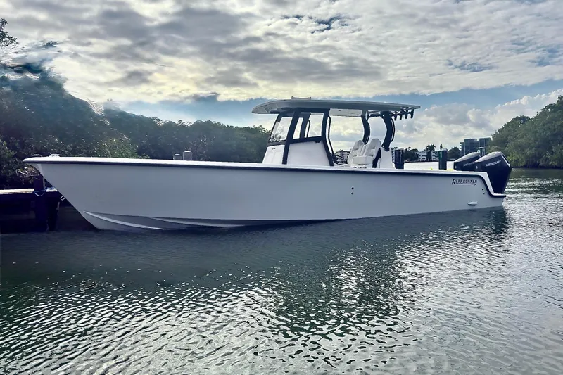 Slide: The Image of 2027 Reef Runner 340 boat on calm water under cloudy sky. - 22